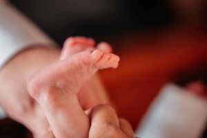 צילום ברית מילה כפות רגליים של תינוק בידיים של אמא