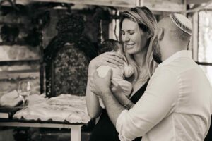 הורים מחזיקים תינוק לפני טקס ברית מילה